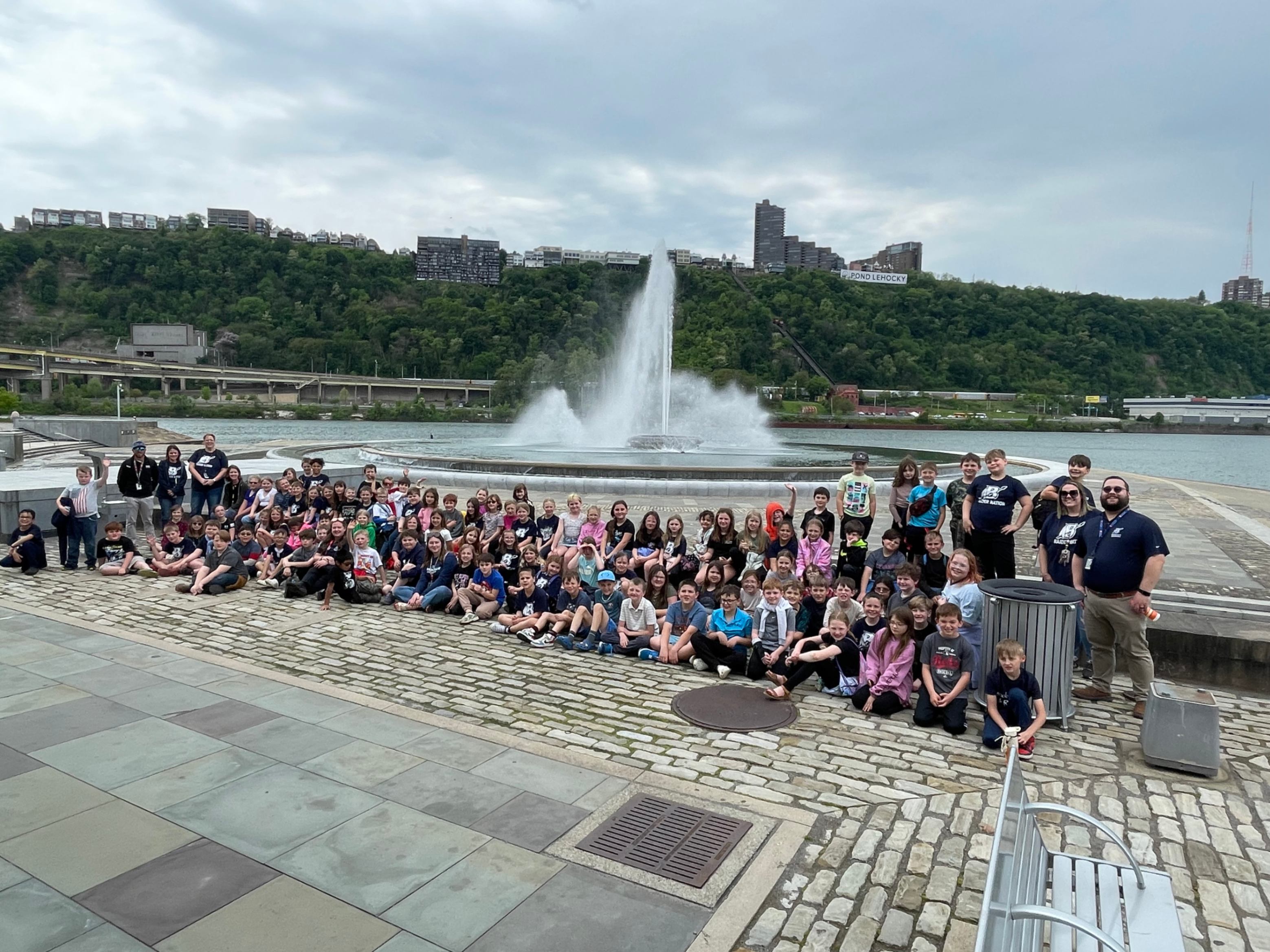 Third graders, teachers and chaperones pose for a group picture near the fountain at Point State Park in Pittsburgh.